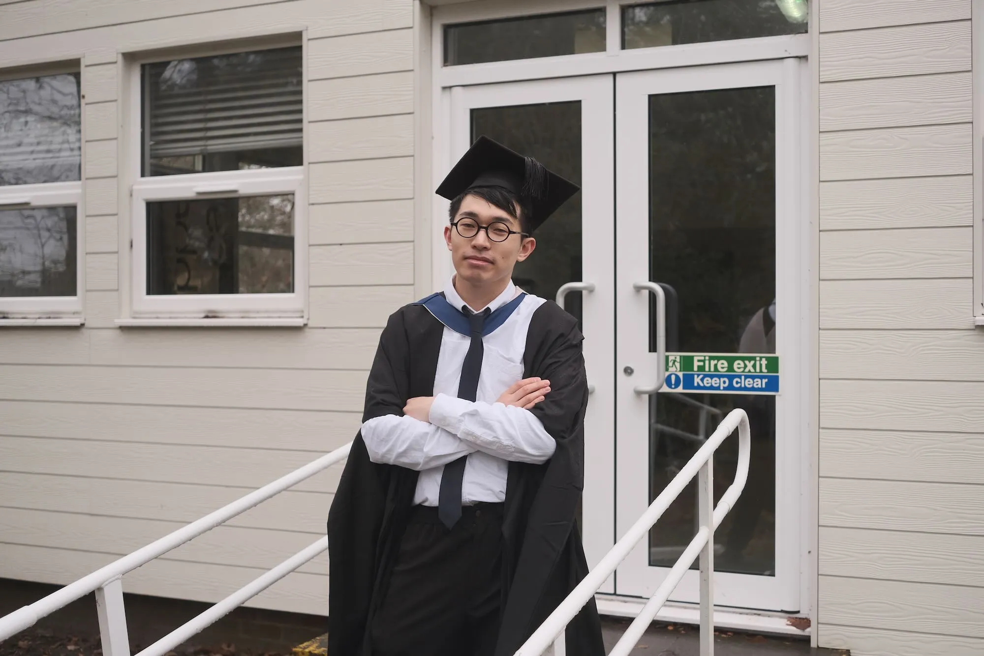 大学院の卒業式の後、教室の前での写真。このとき撮った写真、ずっとジャケットがずれていた…